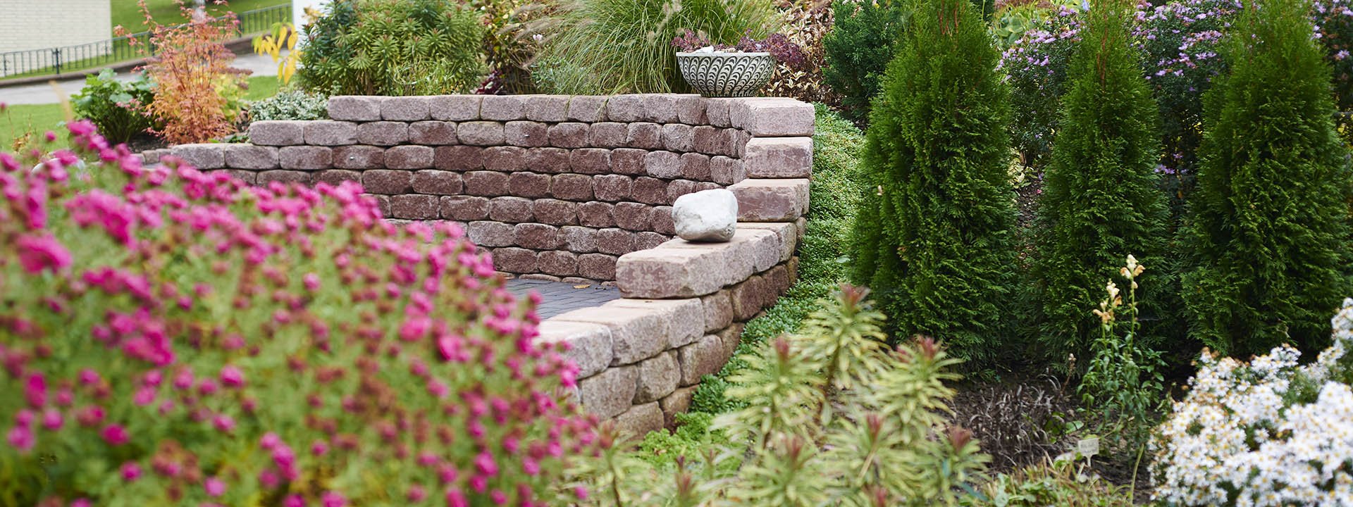 Gestaltete Gartenanlage mit Natursteinmauer und Bepflanzung in Vlotho