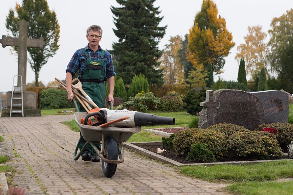 Professionelle Grabpflege in Vlotho Mitarbeiter der Frank und Jörg Prüßmeier GbR mit Arbeitsgeräten auf einem Friedhof